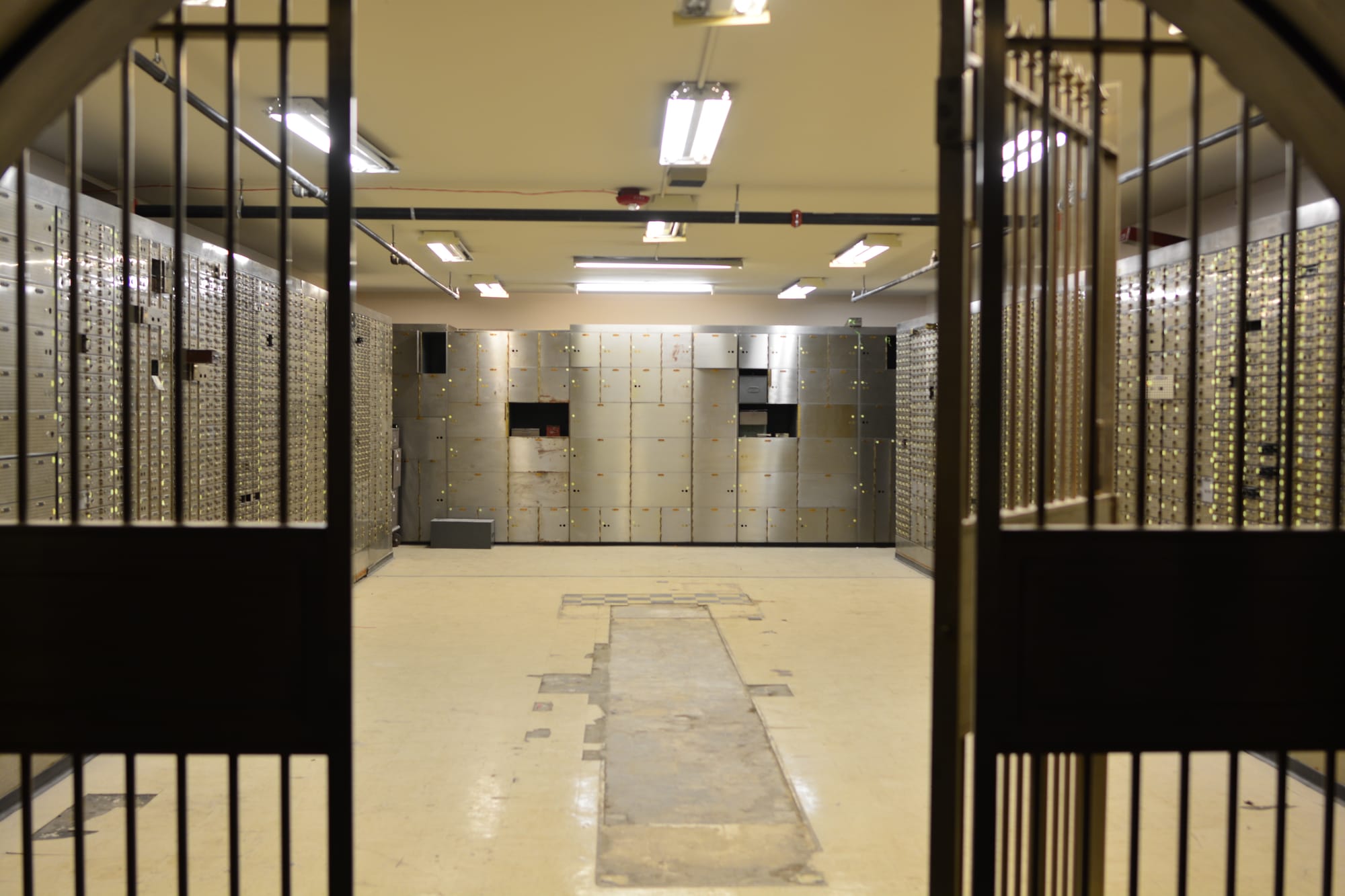 Safe deposit boxes seen through an open vault gate